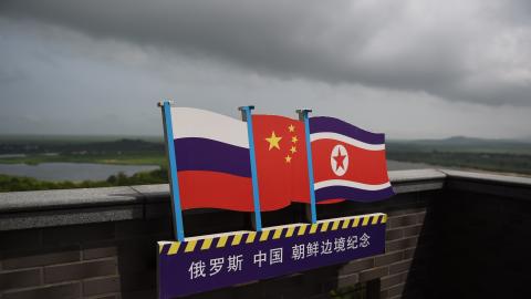 The flags of Russia, China, and North Korea on a viewing tower on the border between the three countries in Hunchun, China, on June 25, 2015. (Greg Baker/AFP via Getty Images)