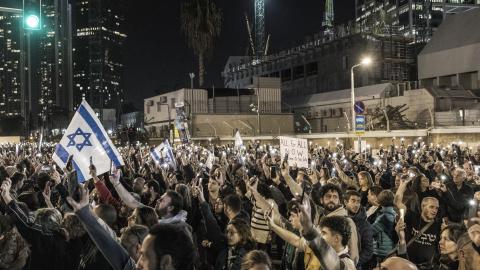 Demonstrators outside the Tel Aviv Museum of Art, now informally called the "Hostages Square," in Tel Aviv hold up their lit mobile phones as they gather during a demonstration calling for the release of hostages on December 9, 2023. (Marco Longari/AFP via Getty Images) 