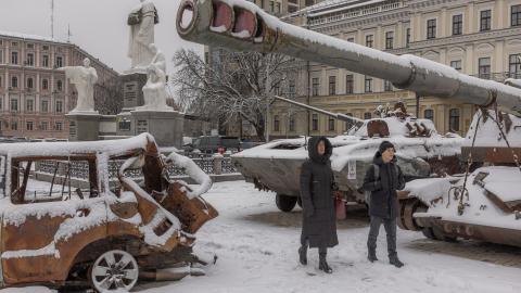 Pedestrians walks past destroyed Russian military vehicles blanketed in snow in front of Saint Michael's Golden-Domed Monastery in downtown Kyiv on November 22, 2023. (Roman Pilpey/AFP via Getty Images)