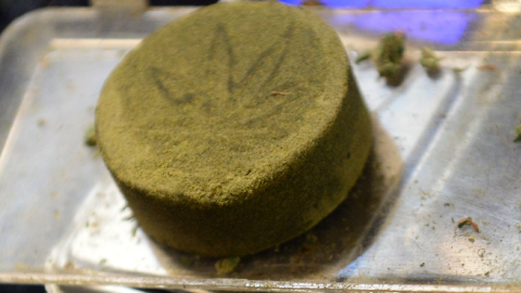 Kief, pressed into a cake of hashish, on a scale at a medical marijuana dispensary in Los Angeles, California on July 4, 2014. (FREDERIC J. BROWN/AFP/Getty Images)