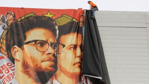 Workers remove a poster-banner for 'The Interview' from a billboard in Hollywood, California, December 18, 2014 a day after Sony announced was cancelling the movie's Christmas release due to a terrorist threat. (Michael THURSTON/AFP/Getty Images)