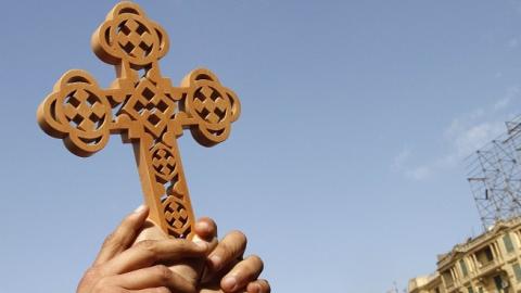 Egyptian Coptic Christians hold a cross high in Cairo's Tahrir square on February 06, 2011. (MOHAMMED ABED/AFP/Getty Images)