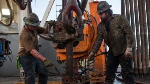 Workers with Raven Drilling line up pipe while drilling for oil in the Bakken shale formation on July 23, 2013 outside Watford City, North Dakota. (Andrew Burton/Getty Images)
