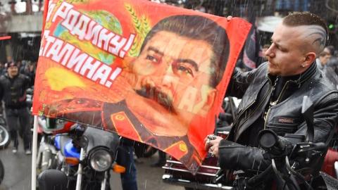 A Russian biker shows a banner depicting Joseph Stalin and reading a WWII slogan 'For the Motherland! For Stalin!' in Moscow on April 25, 2015. (DMITRY SEREBRYAKOV/AFP/Getty Images)