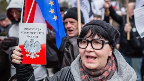 People hold the Polish constitution as they attend the anti-government demonstration against the refusal of polish government to accept verdict of Constitutional Court in Warsaw, March 10, 2016. (WOJTEK RADWANSKI/AFP/Getty Images)