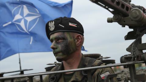 A soldier of the Polish Army sits in a tank as a NATO flag flies behind during the NATO Noble Jump military exercises of the VJTF forces on June 18, 2015 in Zagan, Poland. (Sean Gallup/Getty Images)