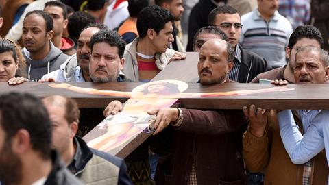 Mourners carry a large cross during a funeral procession on April 10, 2017 at the Monastery of Marmina in the city of Borg El-Arab, for the victims of the blast at the Coptic Christian Saint Mark's church in Alexandria the previous day (MOHAMED EL-SHAHED)