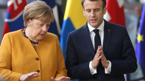 Germany's Chancellor Angela Merkel and France's President Emmanuel Macron (R) talk to each other prior to pose for a family photo on March 22, 2019 in Brussels at the end of an EU summit focused on Brexit. (LUDOVIC MARIN/Getty Images)