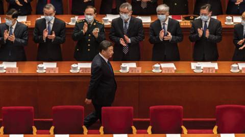 Chinese leader Xi Jinping is applauded by members of his government as he arrives for the closing session of the National People's Congress at the Great Hall of the People on March 11, 2022 in Beijing, China. (Kevin Frayer/Getty Images)
