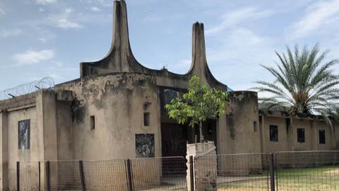 The black flags of “Boko Haram” are still visible on this building (pictured August 2021), which “Boko Haram” used as a prison and execution grounds during its occupation of Gwoza town in Borno state from 2014 to 2015. (James Barnett)