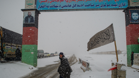 A man looks on at a snow-covered security checkpoint that marks the entrance to Logar province, beyond the southern gate on January 17, 2022, in Kabul, Afghanistan. (Scott Peterson/Getty Images)