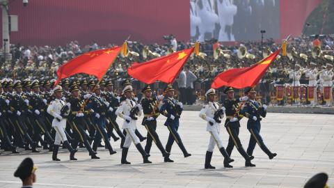Chinese soldiers march with the national flag (C), flanked by the flags of the Communist Party of China (R) and the People's Liberation Army (L) during a military parade at Tiananmen Square
