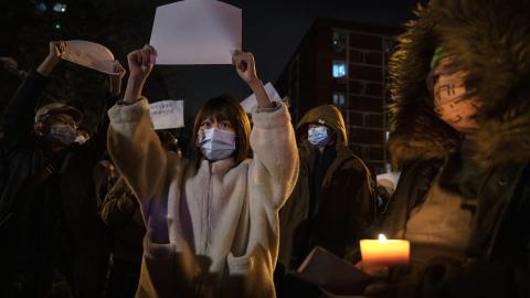 A protester holds up a white piece of paper against censorship as they march during a protest against Chinas strict zero COVID measures on November 27, 2022 in Beijing, China. 