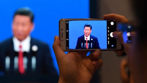 A journalist takes a photo of a live feed of Xi Jinping speaking at the opening ceremony of the Belt and Road Forum in Beijing, China, on May 14, 2017. (Greg Baker/AFP via Getty Images)