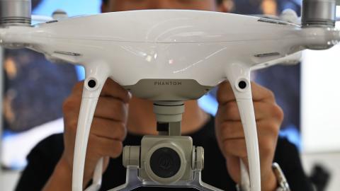 An employee shows a Phantom DJI drone at a store in Shanghai on May 27, 2019. (Hector Retamal/AFP via Getty Images)
