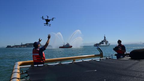 Coast Guard Lt. Trevor Clark prepares to land a Short Range Unmanned Aerial System (SR-UAS) ‘drone’ on the deck of the Coast Guard Cutter Tern with the help of a crew member after operating the vehicle around the Coast Guard Cutter Bertholf (WMSL 750) during the cutter’s return home to Alameda, California, July, 2, 2019, following their 164-day deployment to the Western Pacific.