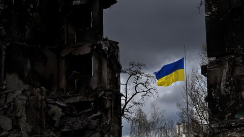 The Ukrainian flag flutters between buildings destroyed in bombardment in Borodianka, Ukraine, on April 17, 2022. (Sergei Supinsky/AFP via Getty Images)