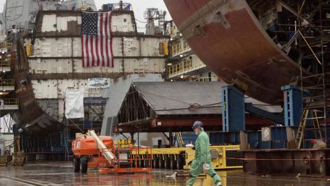 A shipbuilder walks in the yard, with partial ship assemblies behind him, at Bath Iron Works in Bath on Wednesday, December 10, 2014. (Photo by Carl D. Walsh/Portland Portland Press Herald via Getty Images)