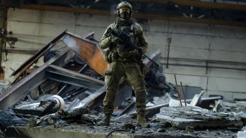 A Ukrainian soldier with an assault rifle stands amid wreckage as debris lie in the garage at a trolleybus depot on January 27, 2023, in Bakhmut, Ukraine. (Yan Dobronosov/Global Images Ukraine via Getty Images)