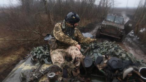 Ukrainian military member drives sitting on top of armored vehicle on a dirt road on February 26, 2023 in Donetsk Oblast, Ukraine. After the withdrawal of Ukrainian troops from Soledar, the main confrontation with the Russian army and its mercenaries take place in February on the outskirts of the city of Bakhmut in the Donetsk Oblast. (Photo by Yan Dobronosov/Global Images Ukraine via Getty Images)