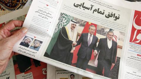 A man in Tehran holds a local newspaper reporting on the China-brokered deal between Iran and Saudi Arabia to restore ties signed in Beijing, on March 11, 2023. (Atta Kenare/AFP via Getty Images)