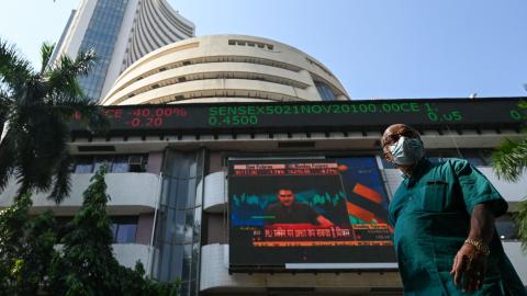 A pedestrian walks past the Bombay Stock Exchange (BSE) building in Mumbai on November 26, 2021. (Photo by PUNIT PARANJPE/AFP via Getty Images)