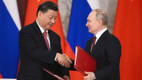 Russian President Vladimir Putin and Chinese President Xi Jinping shake hands during a reception following their talks at the Kremlin on March 21, 2023. (Photo by Pavel Byrkin / SPUTNIK / AFP)
