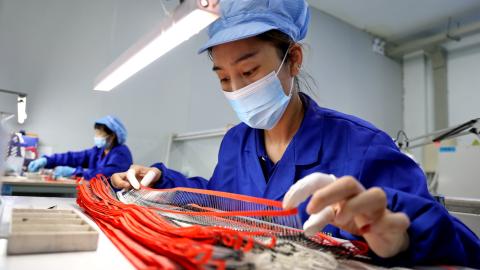 A worker produces high-voltage silicon stack devices at a semiconductor manufacturing enterprise in Shandong, China, on July 17, 2023. (CFOTO/Future Publishing via Getty Images)