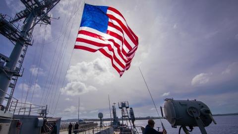 The submarine tender USS Emory S. Land (AS 39) flies the national ensign during the Marine Corps Base (MCB) Camp Blaz Reactivation and Naming Ceremony, Jan. 26. (U.S. Navy photo by Mass Communication Specialist Seaman Luke Wilson)