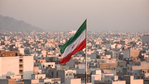 Iranian flag waving with city skyline on background in Tehran, Iran. (Sir Francis Canker Photography via Getty Images) 