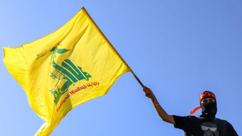 A masked demonstrator waves a flag of the Lebanese Shiite movement Hezbollah during a demonstration supporting the Palestinians in Beirut on October 20, 2023, amid the ongoing battles between Israel and the Palestinian group Hamas. (Photo by JOSEPH EID / AFP) (Photo by JOSEPH EID/AFP via Getty Images)