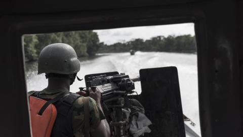 A Nigerian soldier on the back of a gun boat surveys a creek for illegal oil refineries during a patrole on April 19, 2017, in the Niger Delta region near the city of Warri. (Stefan Heunis/AFP via Getty Images)
