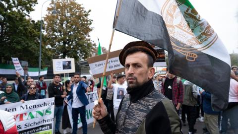 A supporter of Ahmad Massoud, leader of the National Resistance Front of Afghanistan (NFR) and the leading Afghan fighter against the Taliban, holds a flag with an NRF logo as he demonstrates outside Concordia Press Club in Vienna, Austria, on September 16, 2022. (Joe Klamar/AFP via Getty Images)