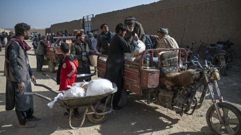 Afghan men load food packets from the World Food Programme onto a vehicle in Baraki Barak, Afghanistan, on January 7, 2024. (Wakil Kohsar/AFP via Getty Images)