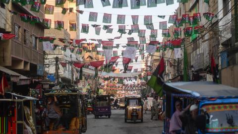Commuters move past the Pakistan People's Party flags hung over a street in Karachi on January 16, 2024, ahead of the country's upcoming general elections. (Asif Hassan/AFP via Getty Images)