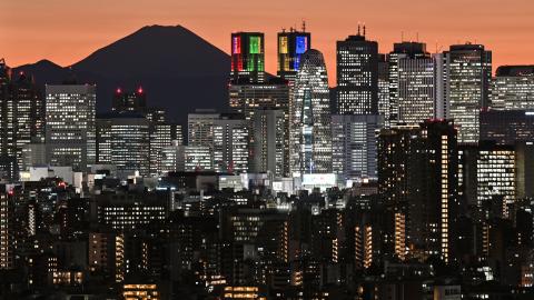 Mount Fuji is silhouetted during sunset behind the high-rise buildings of the Shinjuku area in downtown Tokyo on November 20, 2023. (Photo by Richard A. Brooks/AFP via Getty Images)
