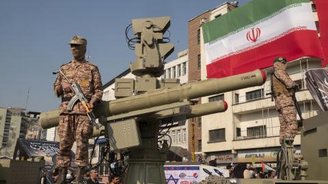 Two Islamic Revolutionary Guard Corps armed military personnel are monitoring an area while standing guard next to an Iranian Majid anti-aircraft missile system during the Ela Beit Al-Moghaddas military rally in Tehran, Iran, on November 24, 2023. (Morteza Nikoubazl/NurPhoto via Getty Images)