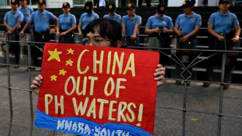 A protester raises a placard during a demonstration to condemn China's aggression in the disputed South China Sea in front of the Chinese Consulate in Makati, Metro Manila, on February 6, 2024. (Jam Sta Rosa/AFP and Getty Images)