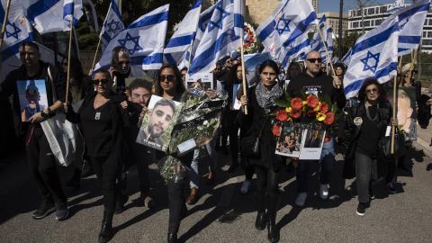 People walk with photos of people killed on the October 7 Hamas attack on Israel's south during a memorial event held by families of victims on February 7, 2024, in Jerusalem, Israel. (Amir Levy via Getty Images)