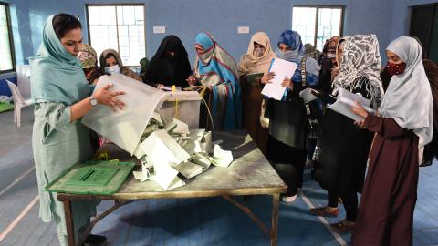 Polling staff open ballot boxes in the presence of poling agents from various political parties as they start counting votes at the end of Pakistan's national elections on February 8, 2024. (Banaras Khan/AFP via Getty Images)