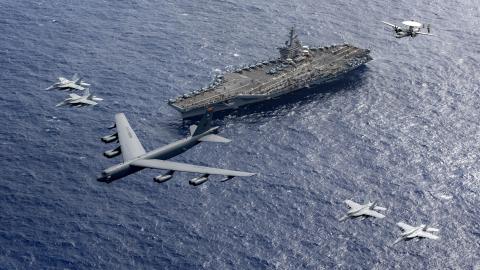 A US Air Force B-52 Stratofortress flies in formation over the Nimitz-class aircraft carrier USS Theodore Roosevelt on February 24, 2024, in the Philippine Sea. (US Navy photo by Mass Communication Specialist 1st Class Thomas Gooley)