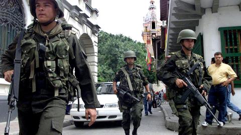 Military police patrol a street in Cartagena, Colombia, on August 29, 2000, as the city as prepares for the visit of President Bill Clinton (Photo by Marcelo Salinas/AFP via Getty Images)