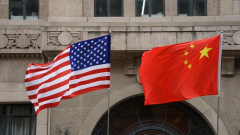 A US and a Chinese flag wave outside a commercial building in Beijing, July 9, 2007. (TEH ENG KOON/AFP via Getty Images)