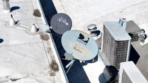 Dish Network and DirecTV satellite dishes are mounted to the roof of a building on October 1, 2024, in San Rafael, California. (Justin Sullivan via Getty Images)