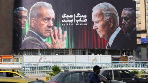 Commuters drive past a billboard bearing pictures of Masoud Pezeshkian, Mohammad Bagheri, and Benjamin Netanyahu in Tehran on October 27, 2024. (Atta Kenare via Getty Images)