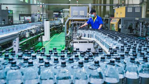 An employee checks the production line of drink bottles at the workshop of Changji Baolong Packaging Technology Development Co., Ltd. on May 6, 2024 in Changji Hui Autonomous Prefecture, Xinjiang Uygur Autonomous Region of China. (Photo by Tao Weiming/VCG via Getty Images)