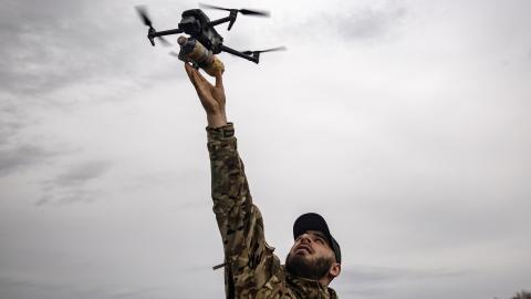 A Ukrainian soldier holds an FPV drone at arm’s length during military exercises on March 15, 2025, in Donetsk Oblast, Ukraine. (Roman Chop via Getty Images)