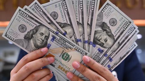 A clerk poses with United States dollar banknotes at a money changer in Jakarta, Indonesia, on May 2, 2024. (Adek Berry/AFP via Getty Images)
