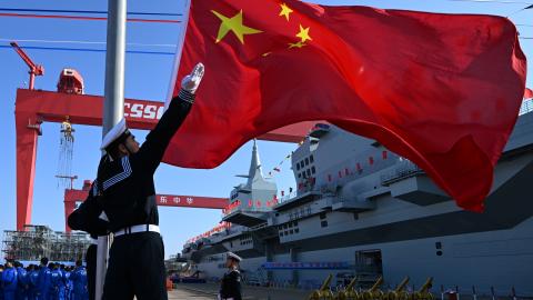 A flag-raising ceremony is held during the launching ceremony to unveil China's first Type 076 new-generation amphibious assault ship, the Sichuan, at Hudong-Zhonghua Shipbuilding, a Shanghai-based subsidiary of China State Shipbuilding Corp, on December 27, 2024 in Shanghai, China. Named after southwest China's Sichuan Province, the independently-developed new vessel was put into the water at a launch and naming ceremony. (Photo by Pu Haiyang/VCG via Getty Images)