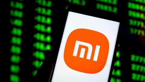 An illustration shows the Xiaomi logo displayed on a smartphone with the stock price chart in background in Chongqing, China, on April 1, 2025. (CFOTO/Future Publishing via Getty Images)